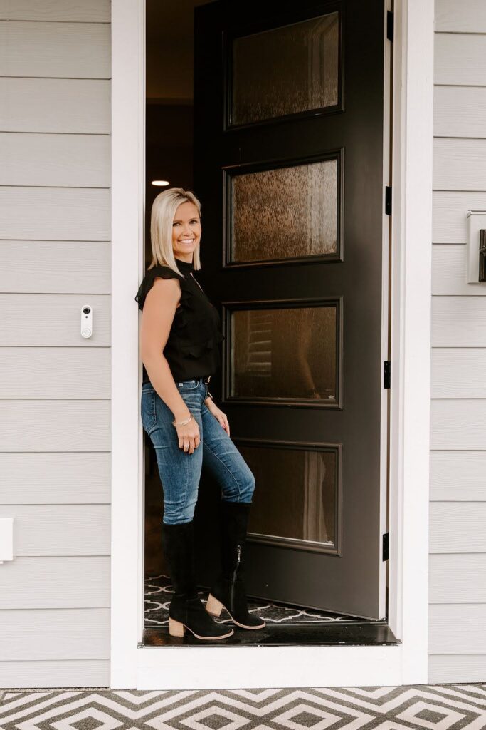 Shelley leaning against the entry to her Air B-n-B